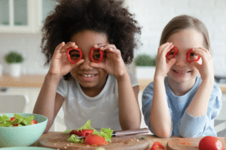 Szczęśliwa rodzina je razem przy stole z owocami warzywami i pełnoziarnistymi produktami